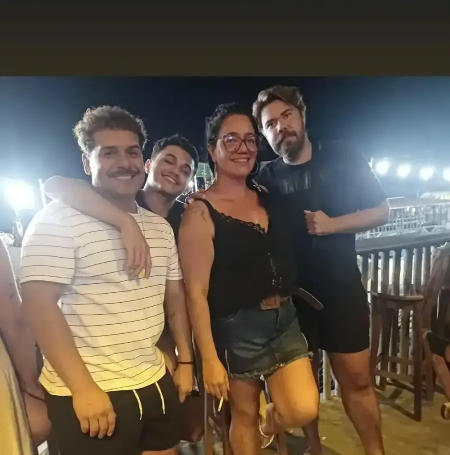 Quatro clientes abraçados no salão à noite, com as luzes do Preá atrás